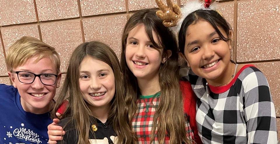 Four students smiling for spirit week (12/2023) 